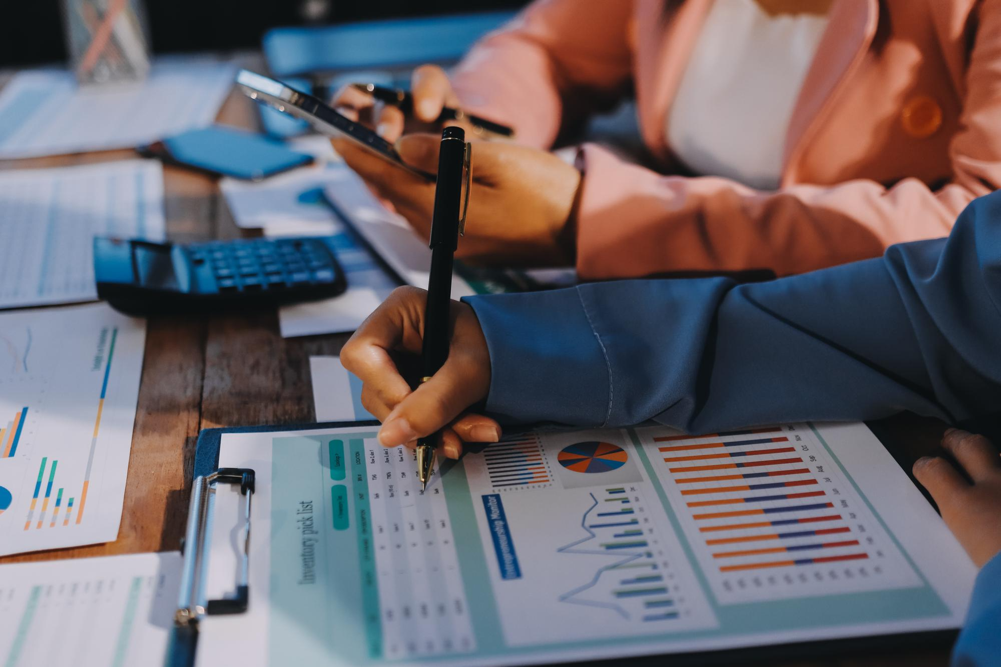 Person analyzing financial data on multiple screens